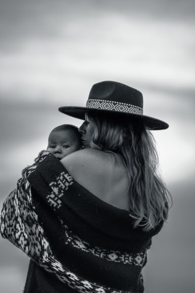 The Motherhood Story – Nähe Mutter küsst ihr Kind auf den Kopf – inniger Moment der Mutterschaftsfotografie