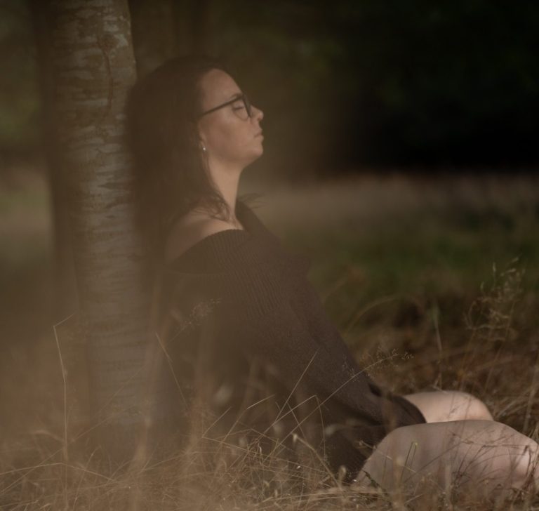 Ankommen bei sich selbst | Empowerment Fotografie Body & Soul Stories Frau sitzt im warmen Abendlicht an einer Birke, Seitenprofil, Empowerment Fotoshooting in der Natur