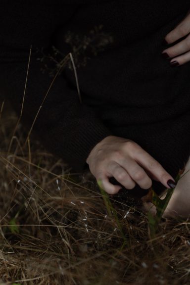 Erdung und Berührung | Body & Soul Stories Hände einer Frau berühren Gras, Detailaufnahme im Dunkeln, Empowerment Fotoshooting in der Natur